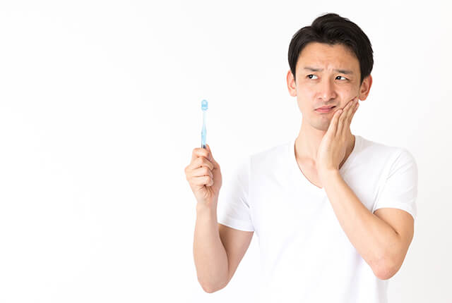 痛そうに頬を押さえている男性